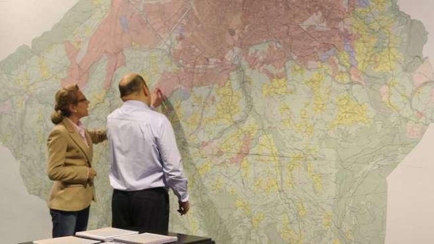 Dos personas consultan un mapa de Gijón.