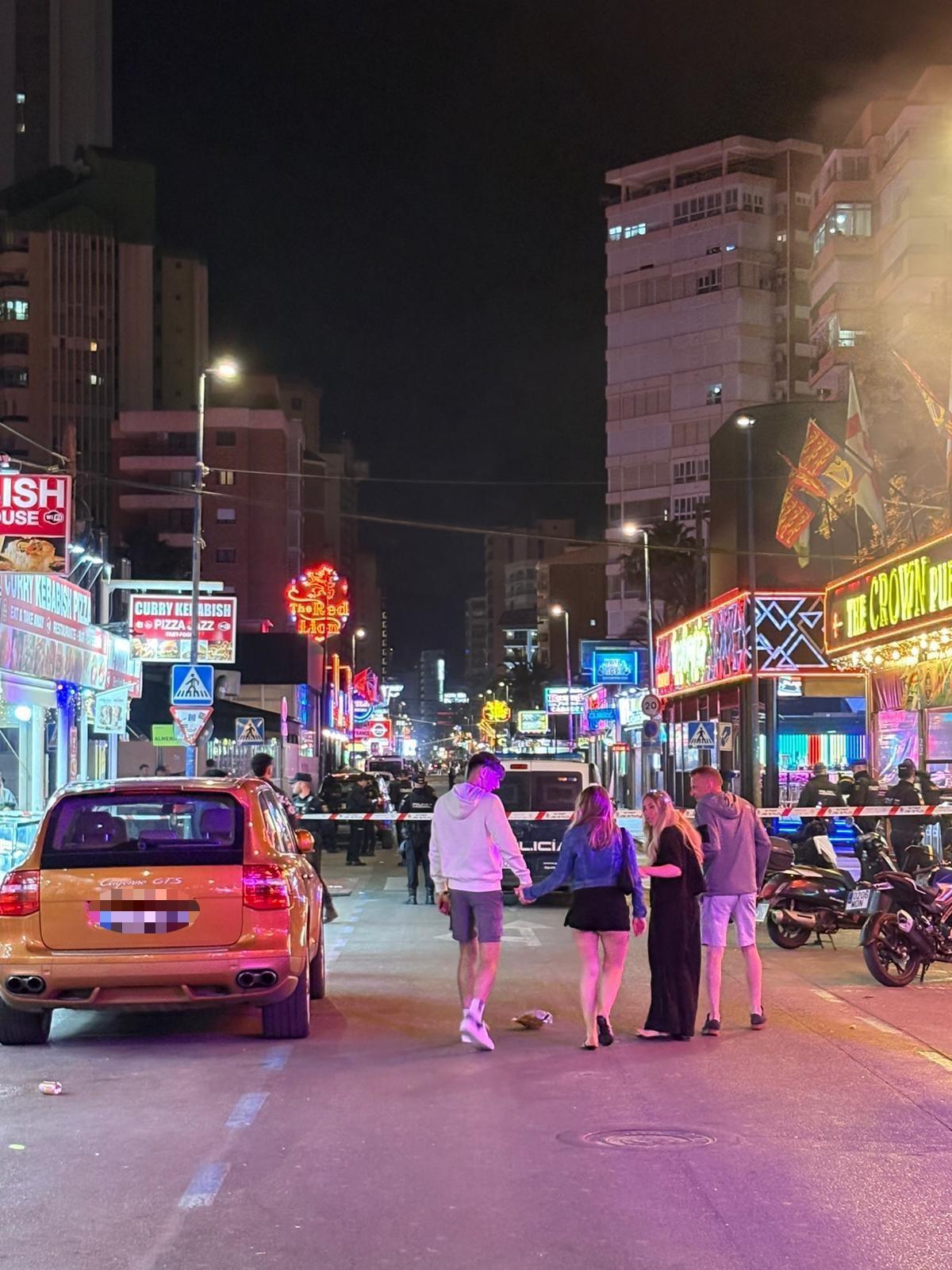 Varios turistas junto al despliegue policial en la zona inglesa de Benidorm.