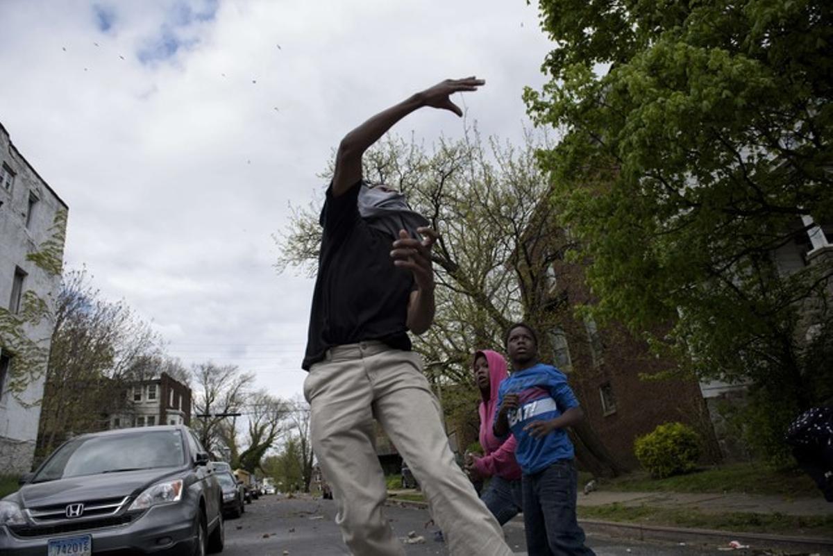 Un joven de Baltimore lanza a una piedra a los agentes.