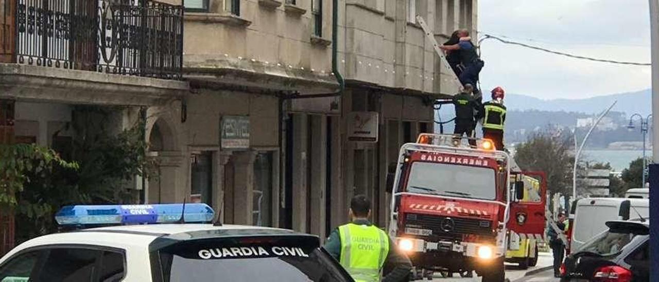 Un guardia civil rescata a la víctima por una ventana con ayuda de un camión escalera. // M. Muñiz