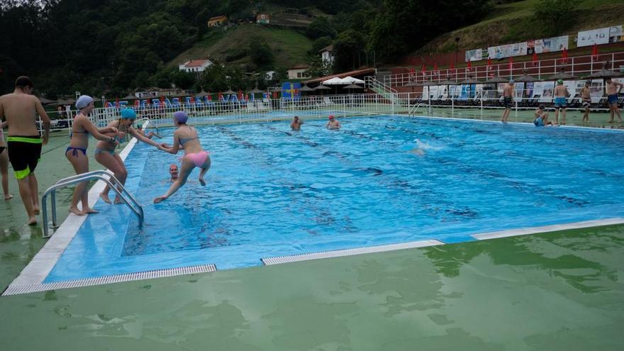 Varios niños disfrutan de un baño en la piscina de Turón.