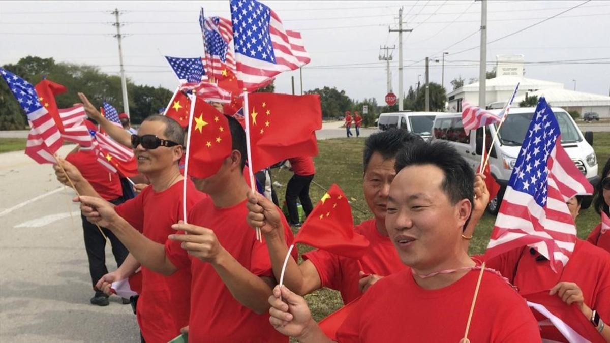 Partidarios de Xi Jinping esperan la llegada del mandatario al aeropuerto internacional de Palm Beach.