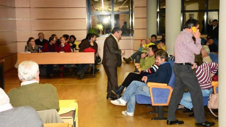 El alcalde, ayer, hablando con un afectado mientras que otro se dirige a él, detrás de la oposición. // G.N.