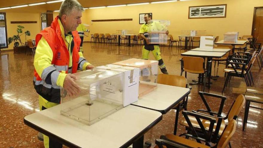 Operarios municipales colocando las urnas ayer en el centro social de O Calvario, en Vigo. // R.Grobas