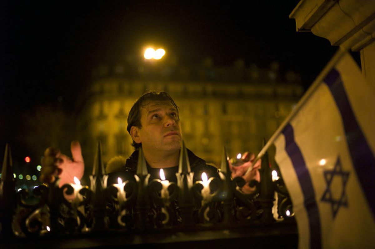 Un home participa en la vetlla en record a les víctimes de l’escola Ozar Hatorah de Tolosa, ahir a la nit a París.