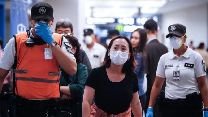 Policías argentinos separan a turistas europeos en el aeropuerto de Buenos Aires.