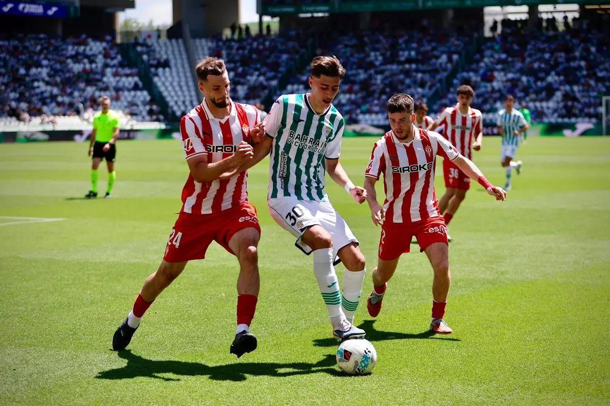 Dani Requena protege el esférico ante la presión de Justin duranta el Córdoba CF-Sporting de Gijón.
