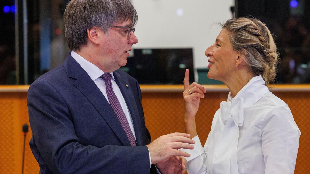 La vicepresidenta segunda y ministra de Trabajo, Yolanda Díaz (i) habla con el presidente de Junts, Carles Puigdemont (d), en una imagen de archivo.