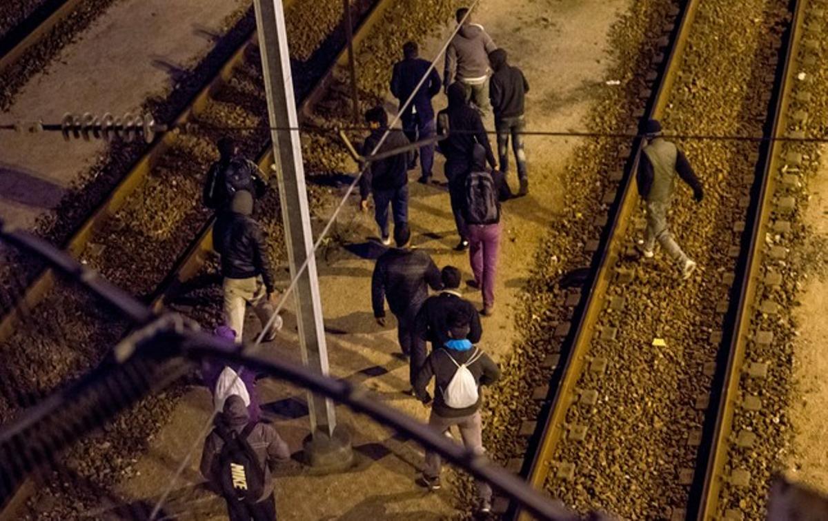 Un grup d’immigrants caminen per les vies de l’Eurotunnel, aquest dimarts.