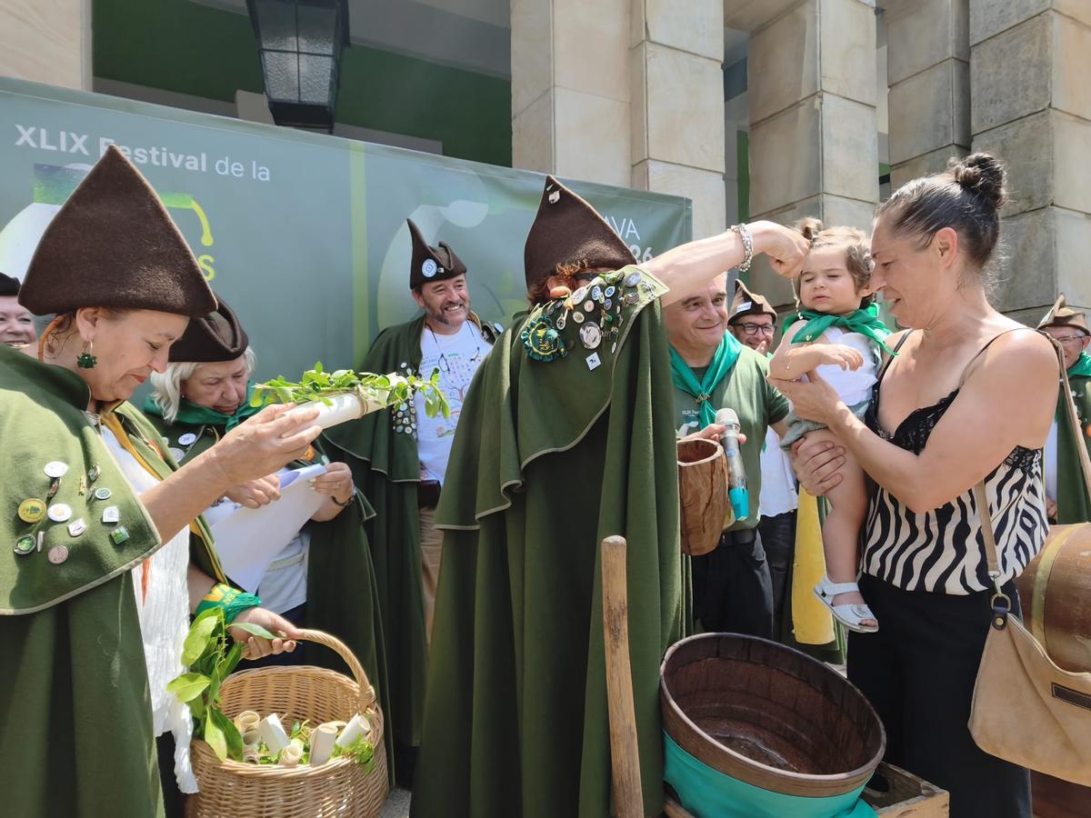 El bautismo sidrero de una veintena de bebés en el Festival de la Sidra de Nava, en imágenes