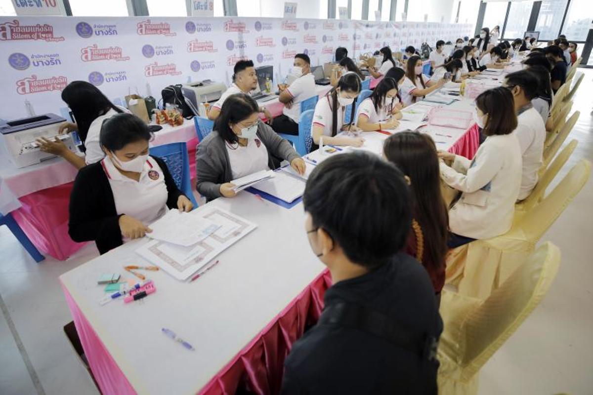 Una pareja casada se va después de una ceremonia de matrimonio masivo para celebrar el Día de San Valentín en una oficina de distrito en Bangkok, Tailandia