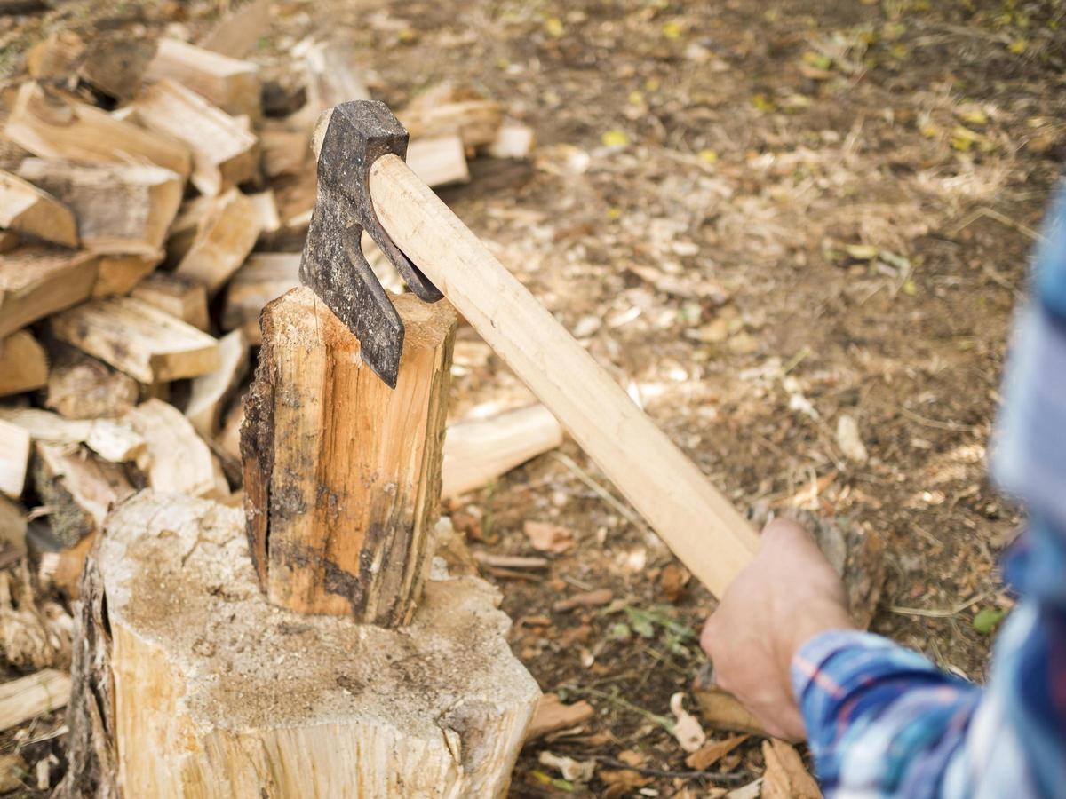 Una persona corta leña con un hacha