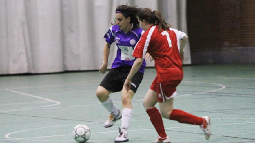 Tania se lleva el cuero ante la presencia de una jugadora del Universidad de Valladolid. / Foto Javier de la Fuente