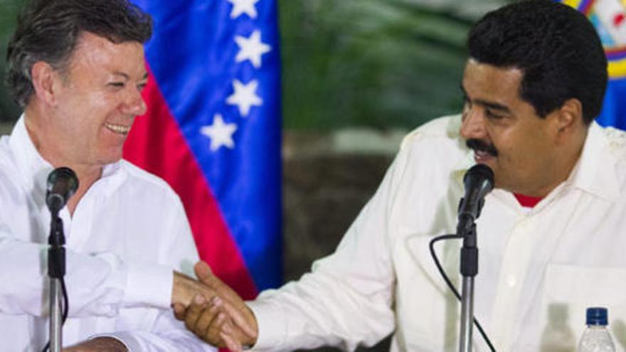 Juan Manuel Santos y Nicolas maduro se estrechan la mano