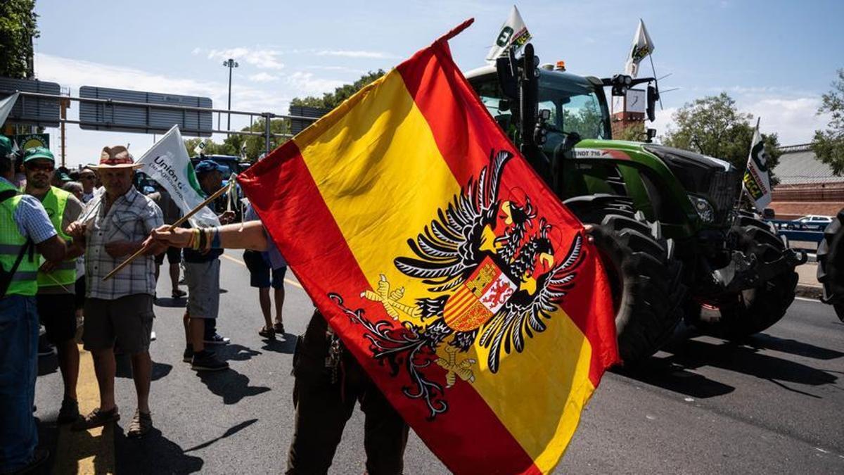 Un manifestante hace ondear una bandera austracista parecida a la franquista en la llegada de tractores a Madrid en la protesta del pasado 5 de julio.