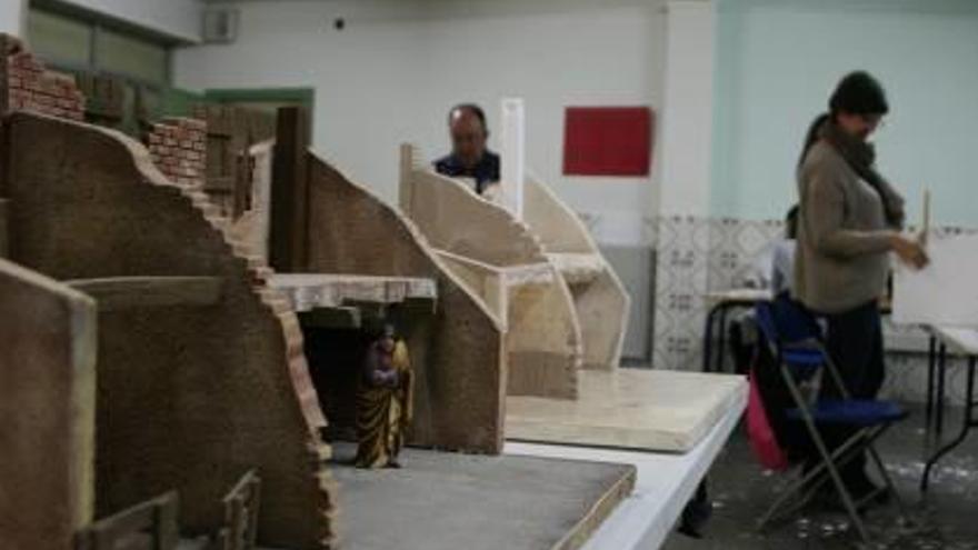 Estructuras del belén que se construye en el taller. A la derecha, Roberto Martínez, trabajando en uno de los nacimientos.