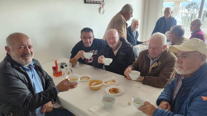 Vecinos probando tazas de vino en el furancho de Cunchido.
