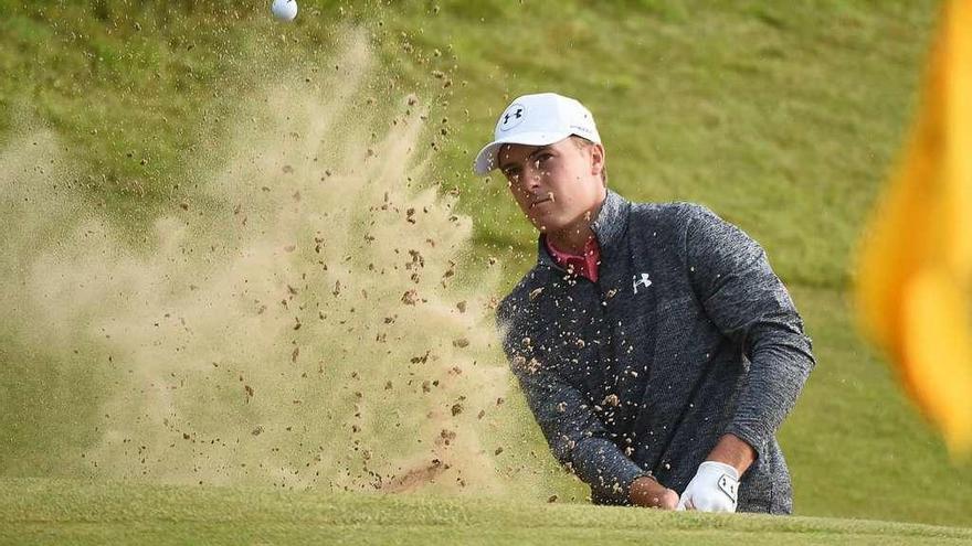 Spieth saca la bola de un búnker durante el recorrido de ayer. // Efe