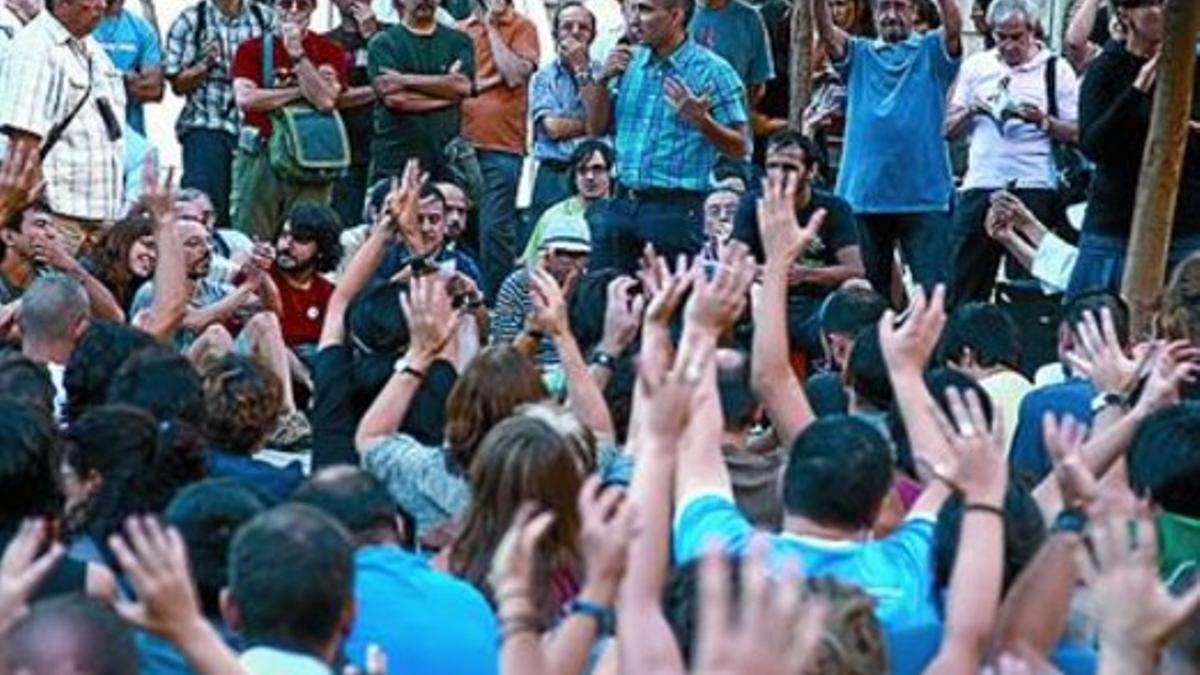 Participantes en la asamblea de Madrid levantan las manos, ayer.