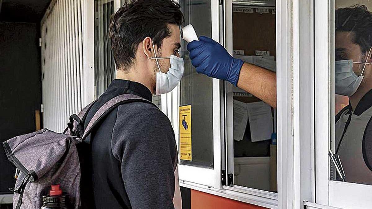 Un empleado del Príncipes toma la temperatura a un deportista.