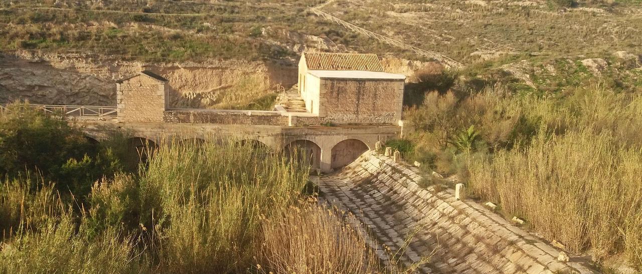 El azud de Mutxamel, con las casas del Assuter y de Compuertas y, arriba a la derecha, el centro de recepción de visitantes en la zona recreativa La Sabateta.