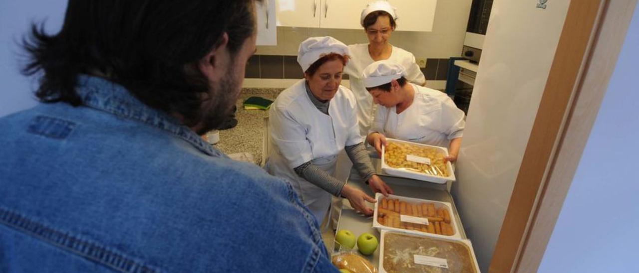 Tres trabajadoras atienden a un usuario del comedor social, en una imagen de archivo. | LNE