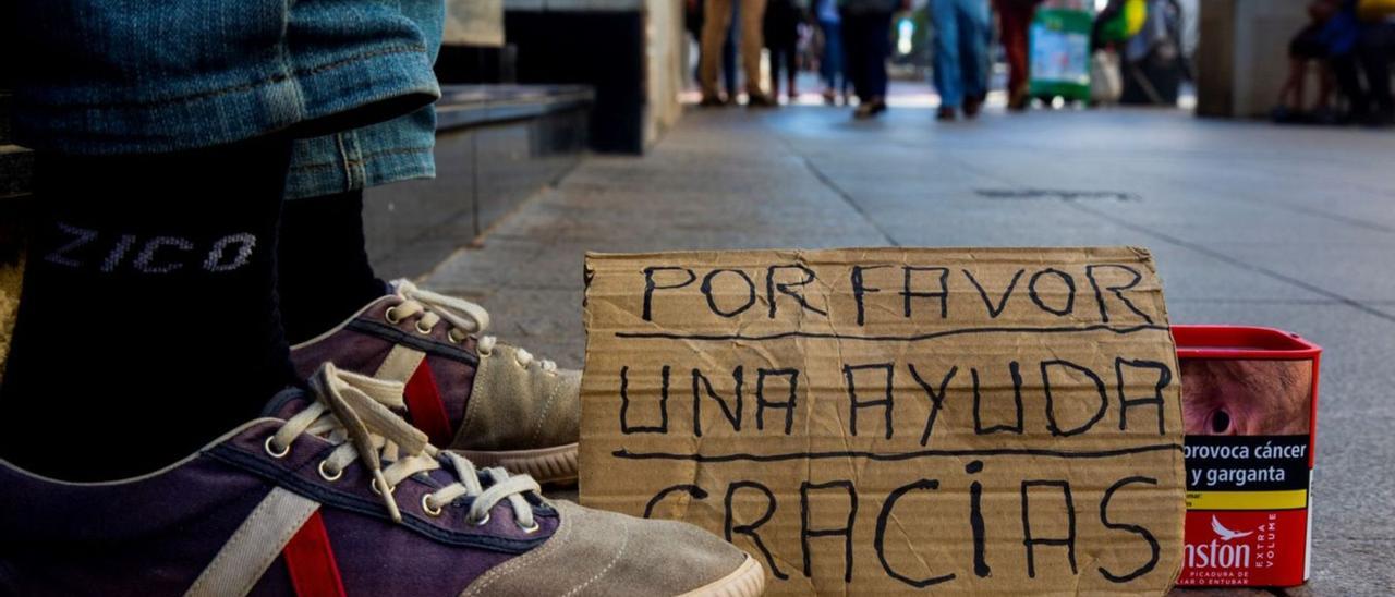 Un hombre pide ayuda en una céntrica avenida de la ciudad de Alicante, en una imagen de archivo.  | RAFA ARJONES