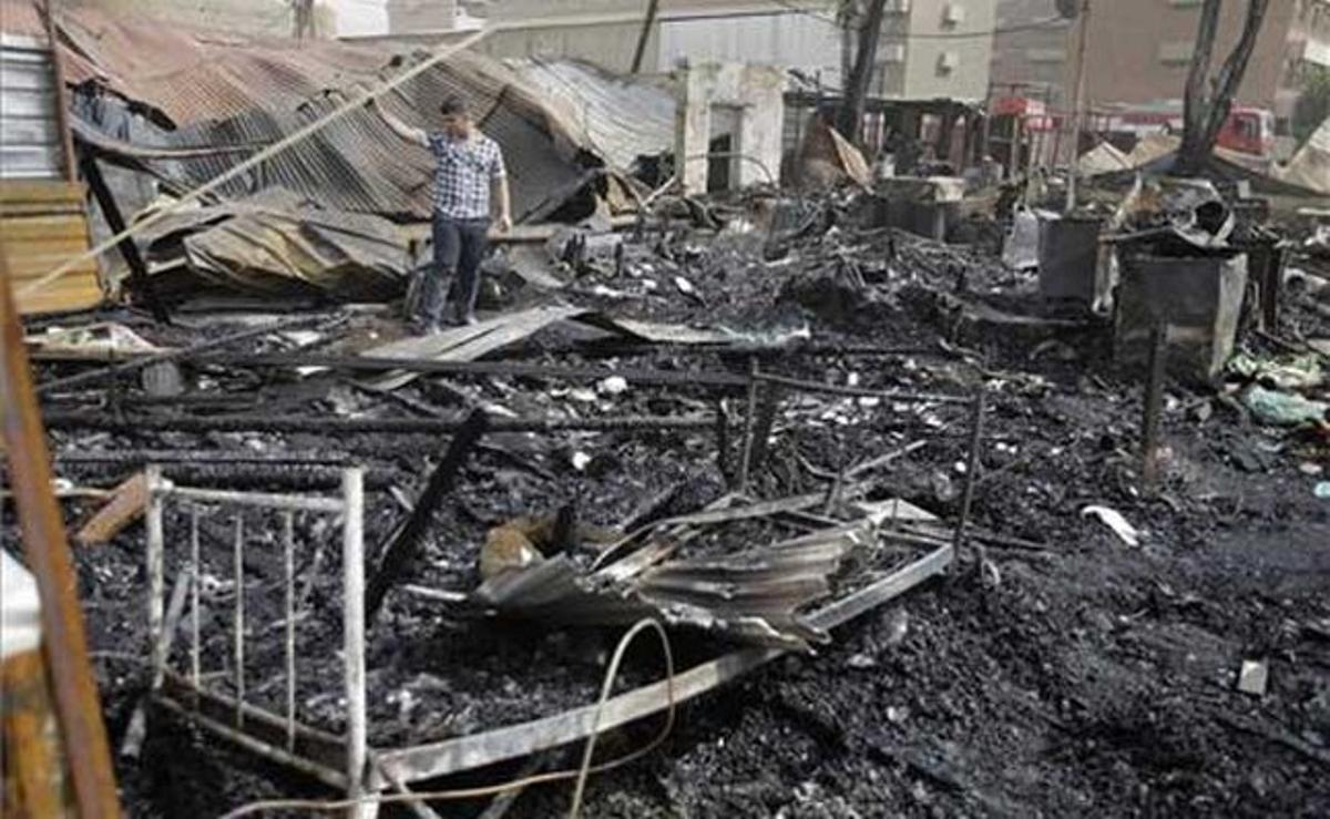 Un home iraquià inspecciona el lloc de l’atac amb coets a un complex residencial a Bagdad, a l’Iraq.