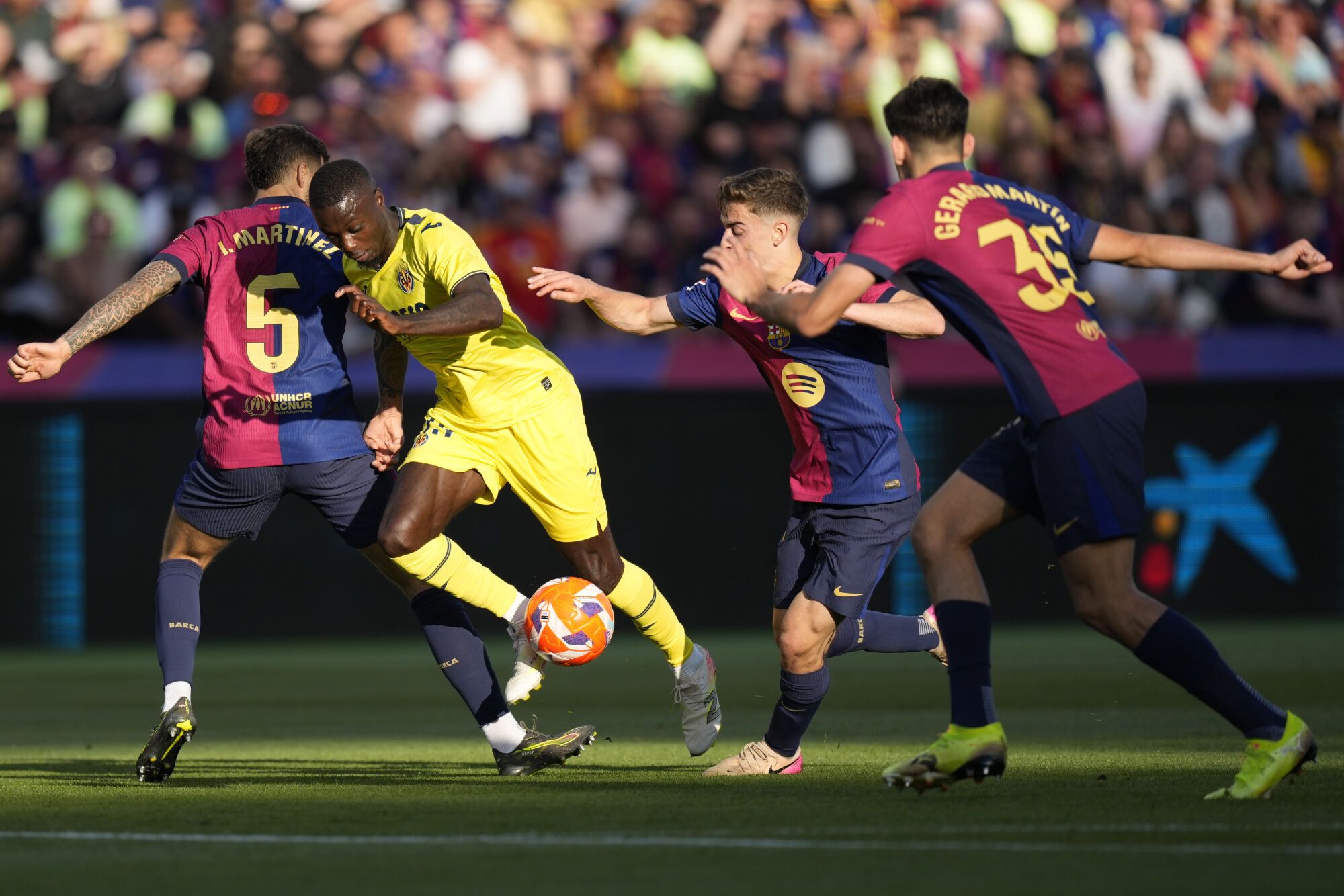 BARCELONA, 18/05/2025.- El delantero marfileño del Villareal Nicolas Pepe (2i) rodeado de jugadores del Barcelona durante el encuentro de la jornada 37 de LaLiga entre FC Barcelona y Villarreal CF disputado este domingo en el Estadio Olímpico de Montjuic. EFE/ Enric Fontcuberta