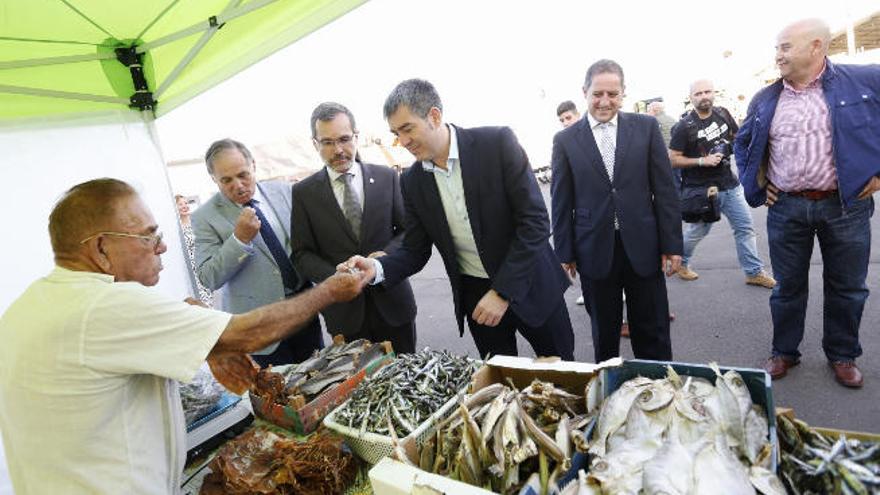 Las autoridades Estárico, Morales y Clavijo en un puesto de pescado salado en la inauguración del recinto.