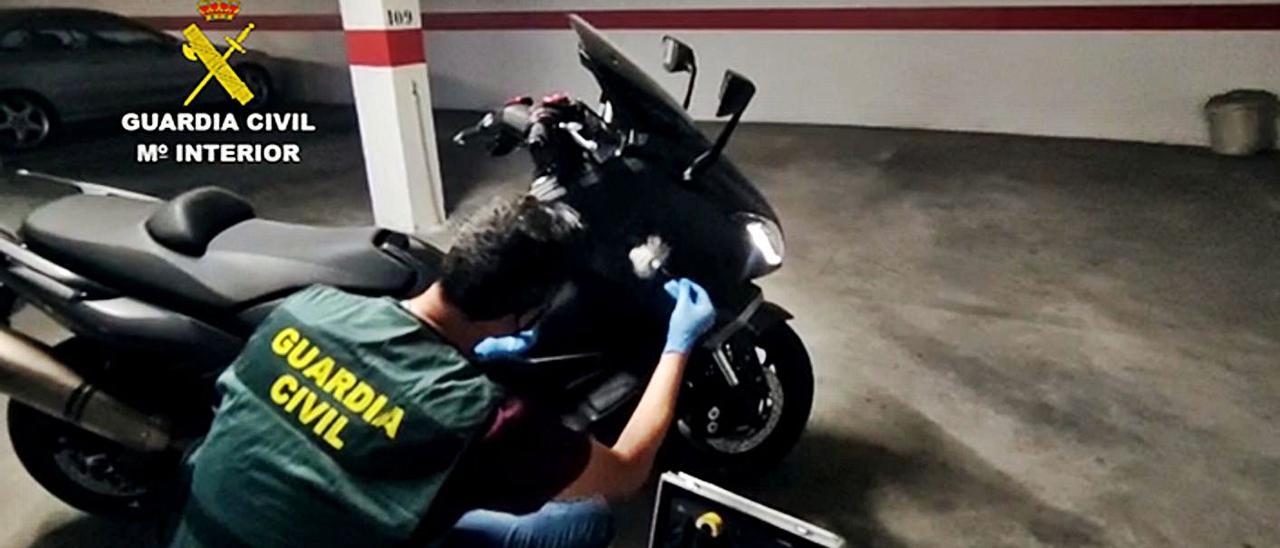 Agentes de la Guardia Civil, con una de las motocicletas utilizadas por el estafador. | INFORMACIÓN