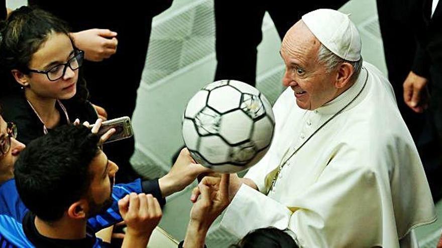 El Papa recibe un balón de fútbol de un equipo de juveniles, en el Vaticano.