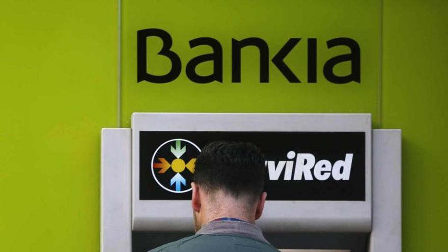 Un hombre usa un cajero automático de Bankia.