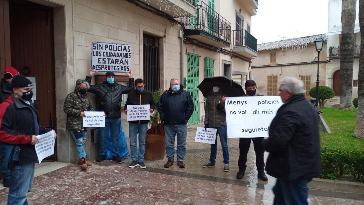 El alcalde Monjo pasa por delante de los agentes que le esperaban con pancartas el viernes en el ayuntamiento de Santa Margalida.