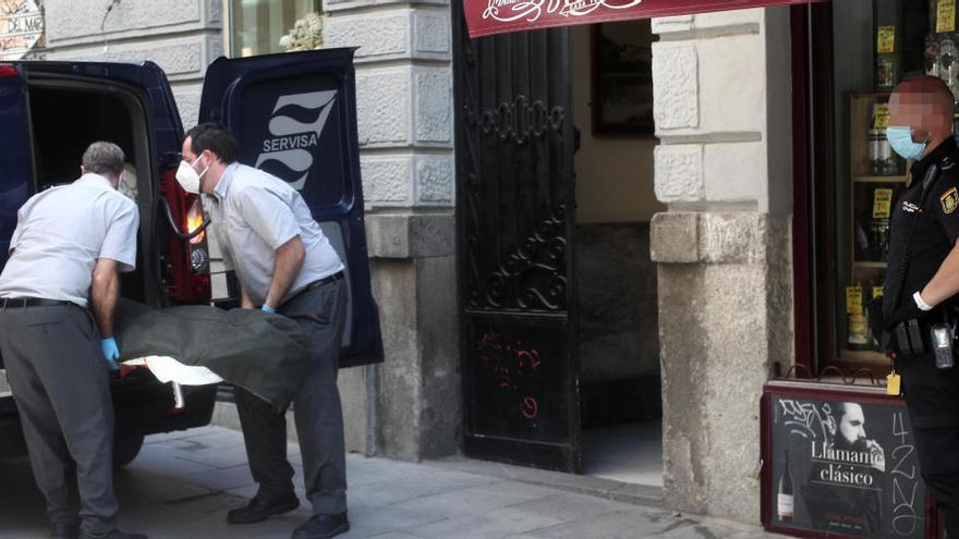 Dos operaris de la funerària retiren les despulles mortals de mare i fill.