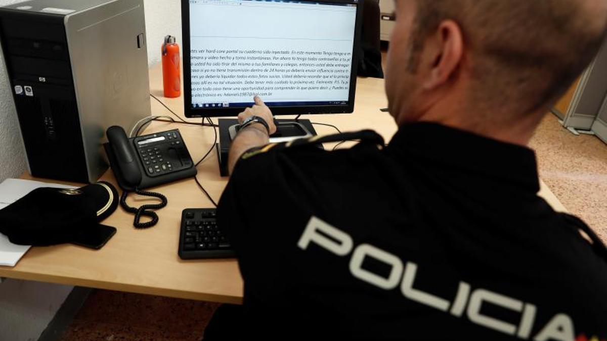 Un policía nacional mira mensajes de un caso de sextorsion. Mariscal EFE