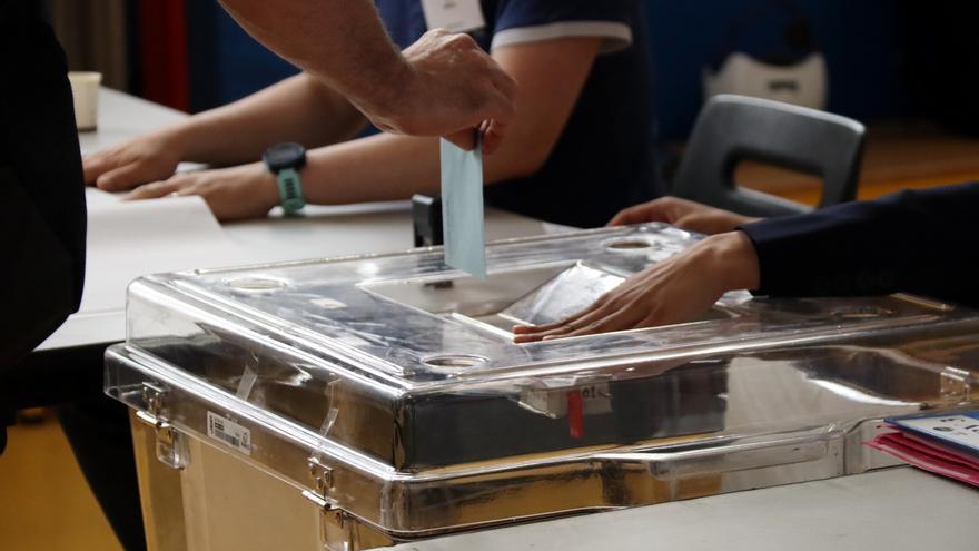 Una mà introdueix una papereta electoral en una urna en les eleccions legislatives a França.