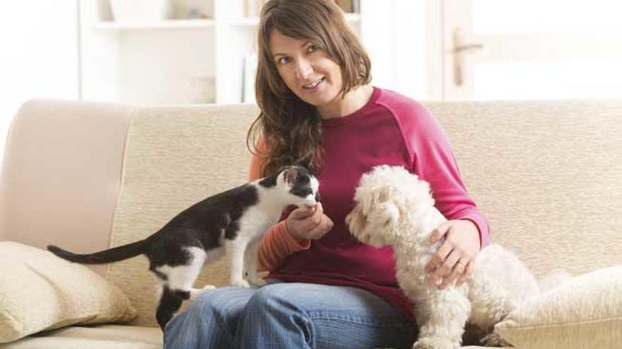 Una mujer acompañada por un perro y un gato.