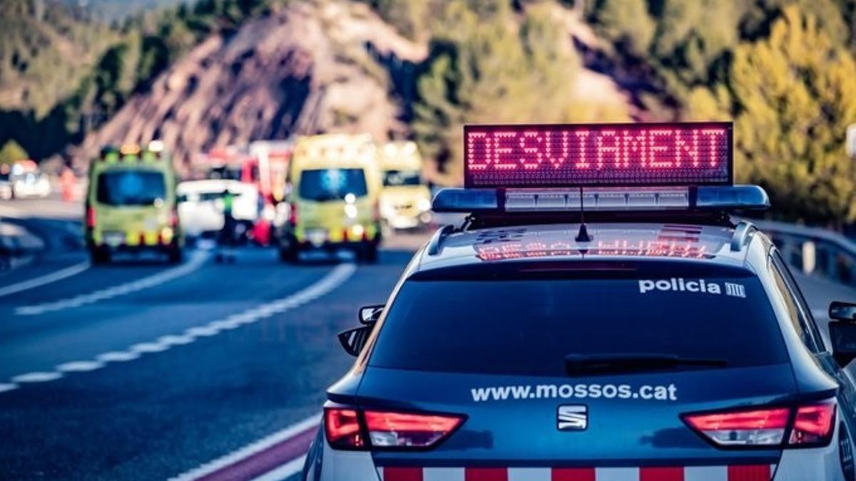 Un coche de los Mossos d'Esquadra y ambulancias del SEM en un accidente de tráfico. 