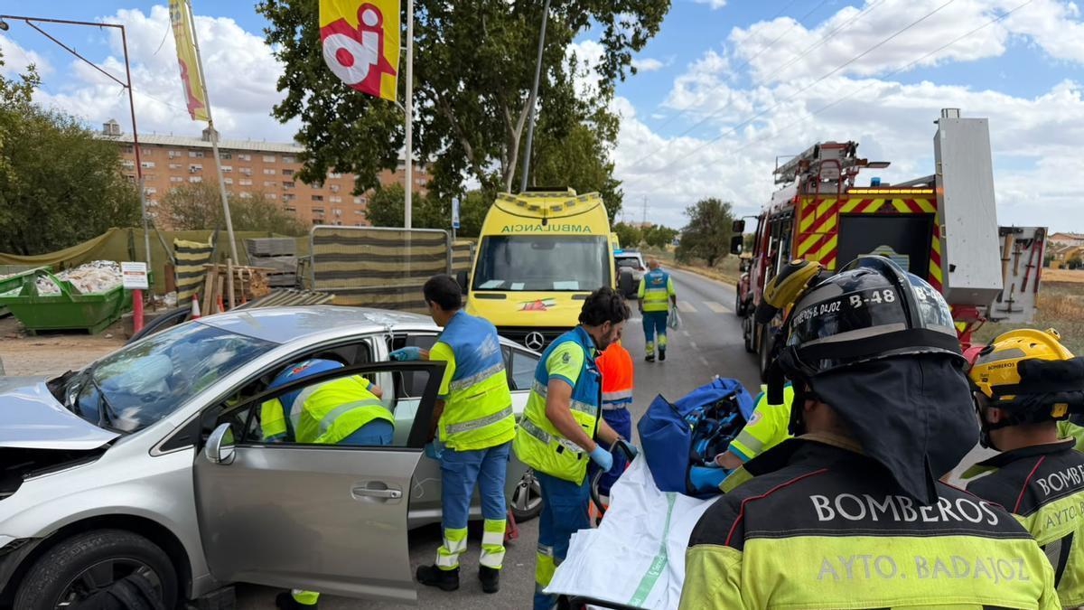 Los equipos sanitarios y los bomberos auxilian a la conductora tras el accidente.