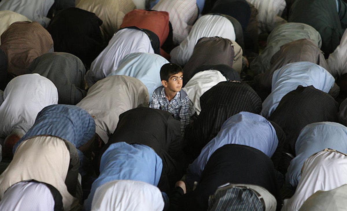 Un nen iranià aixeca el cap entre un grup de fidels durant la pregària del divendres al campus de la Universitat de Teheran.