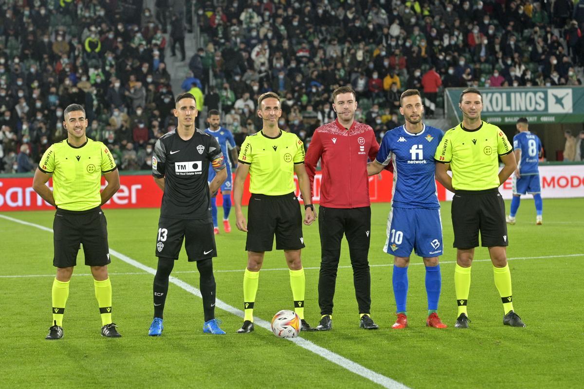 El trencilla Pizarro Gómez junto a su equipo arbitral y los capitanes del Elche y el Betis, Edgar Badía y Sergio Canales, antes de comenzar el encuentro liguero