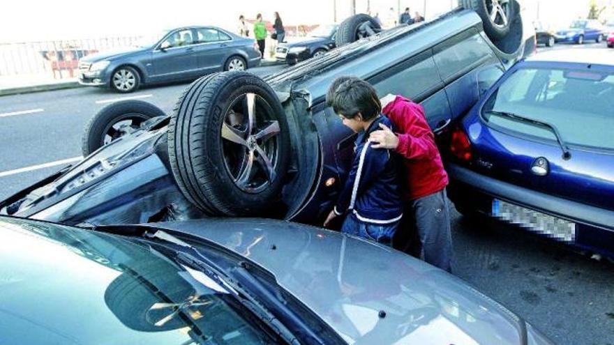 Dos niños observan el vehículo accidentado ayer en Vigo. / marta. g. brea