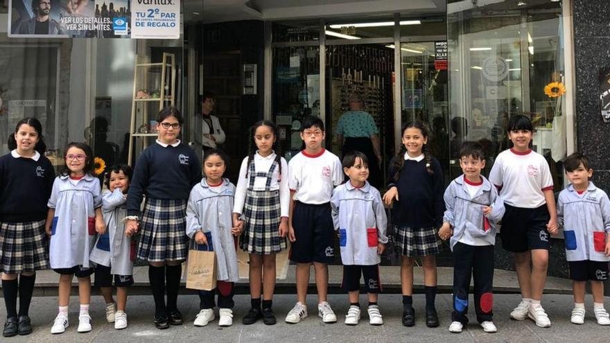 Alumnos del CPR Plurilingüe La Grande Obra de Atocha delante de Óptica Lázaro