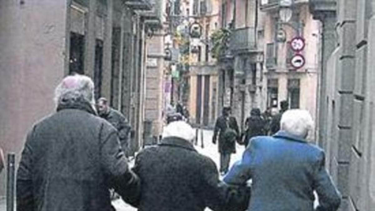 Unos jubilados caminan por Barcelona.