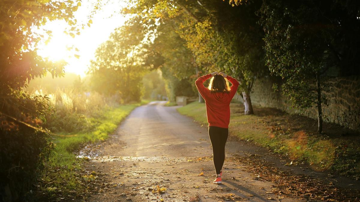 Una mujer practica ejercicio de cardio al aire libre.