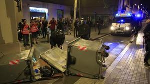 Contenedores tumbados y coches de la policía en Gràcia, la noche del martes.