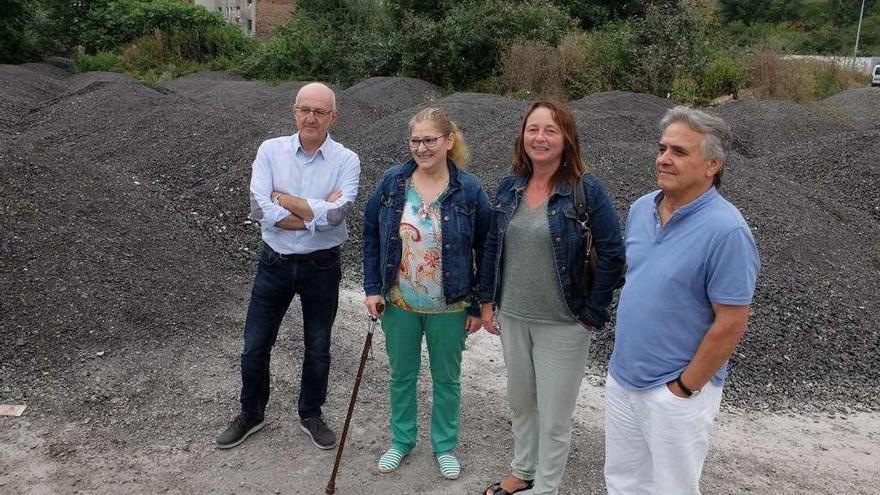 Los socialistas Hilario Feito, Gloria Muñoz, Norma Rebollo y Eduardo Martín, en Oñón, con los montones de asfalto a sus espaldas, durante una visita en verano.