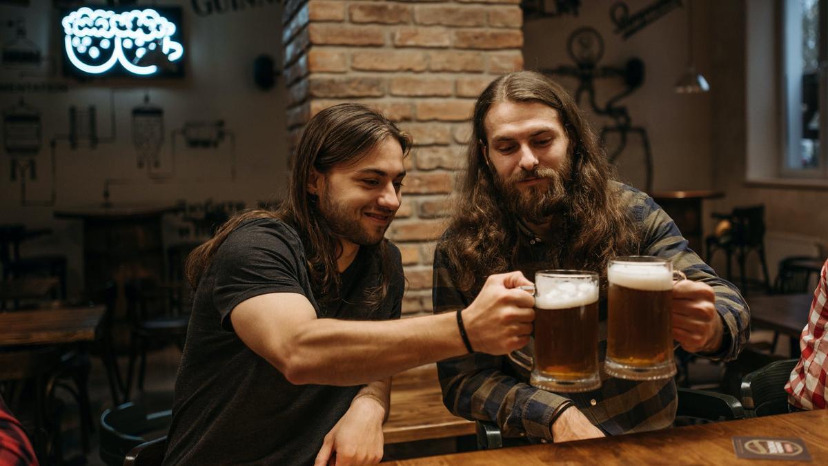 Jóvenes beben cerveza en un bar