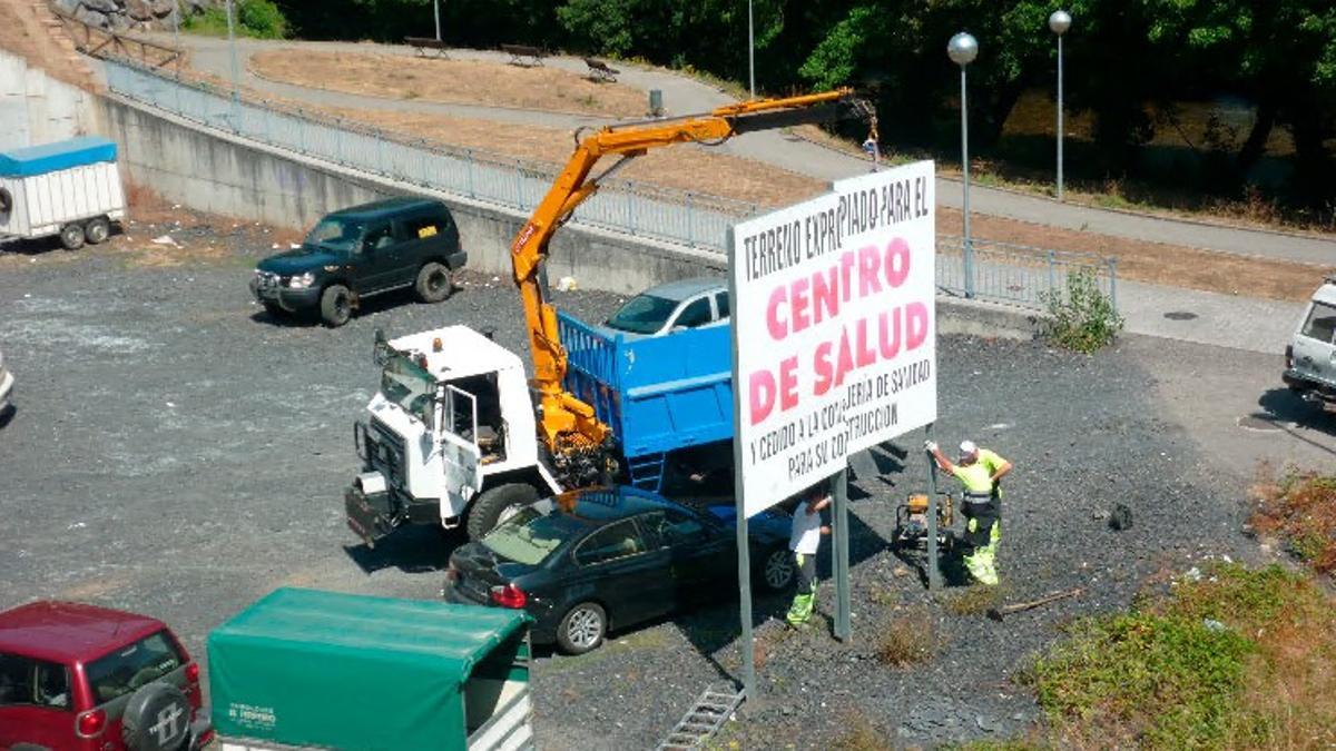Solar de La Cortina en el momento que retiraban el cartel que exigía el centro de salud, en 2015.